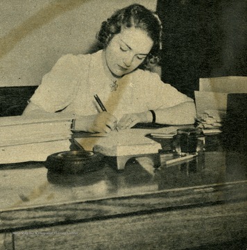 Sara Rehm was a soloist on the "It's Wheeling Steel" radio broadcast. Caption with photograph reads: "Back in Wheeling after less than two days as Cinderella, Sara was greeted by the same home-town band, same cheering citizenry, and at the office, same desk!"