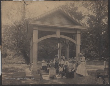 A group of unidentified persons gather around the originator spring home.