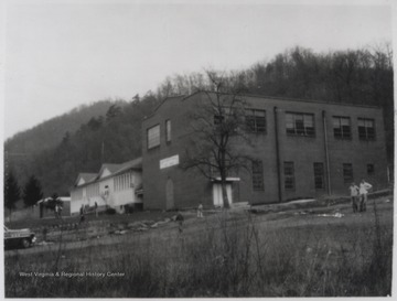 View from across the lawn. Two unidentified men stand int he parking lot to the right.