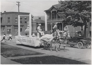 Two horses pull the float down Temple Street. 