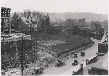 Cars drive past the construction. 