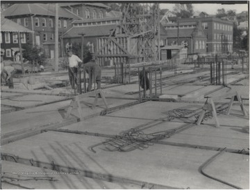 Three unidentified men are pictured within the construction site. 