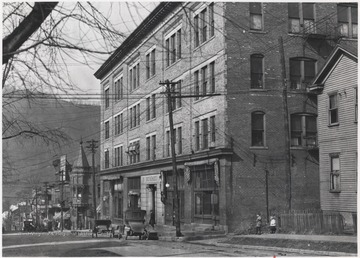 Two unidentified children are pictured on the sidewalk of a relatively empty street. To the right is the Big 4 Building. Down the street is the intersection with TempleStreet.