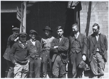 The boys stand below a sign that reads, "Willard Storage Batteries." Subjects unidentified.