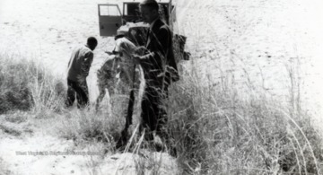 Edward C. Tabler and other individuals preparing to cross the west bank of the Ingwisi River, Africa.