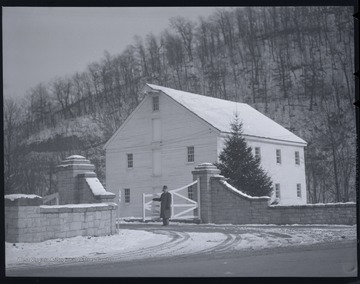 The photo's description reads, "Christmas Cart." An unidentified man stands by the gate, perhaps to close it. Fresh cart tracks are seen in the snow on the road. 