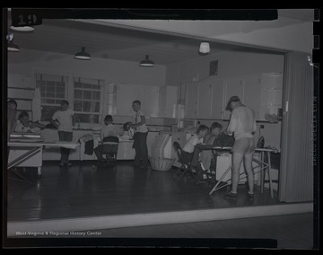 Campers work in the kitchen for a class at an unidentified 4-H camp location. 