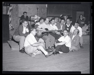 A group of men sing together by the stage at the leadership conference at the State 4-H Camp. 