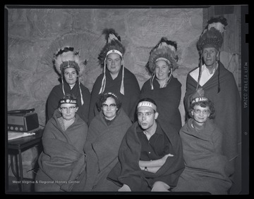 A group of unidentified individuals pose in their Native American costumes. 