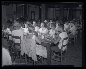 Families are gathered around tables at the show's dining room. 