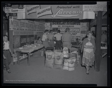 Individuals pass through the Larro Feed Co. tent and examine the supplies on display.