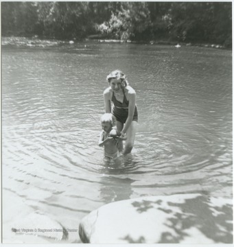 A young woman holds her son up in the water. Barger Springs, also known as Greenbrier Springs, is located along the Greenbrier River. 