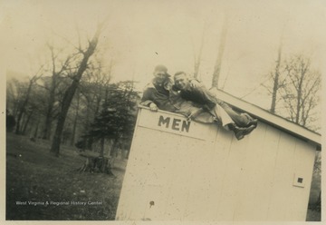 Cooper, left, and Feather, right, pose on top of the bathroom shack. 