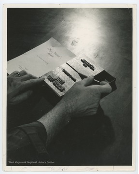 An unidentified man sets the type for the title page of "My Mother's House", a short story by Pearl S. Buck.