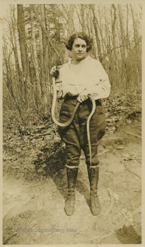 Poland holds up a snake as she poses for a photo. 