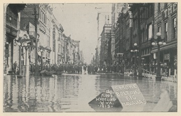 Photo postcard of a crowd of people on Market Street in Wheeling, W. Va. during a 1913 flood. Several business signs are visible, including a sign which reads "Smoke Bolton's Big Havanas." Postcard is part of a souvenir book of 1913 flood images.