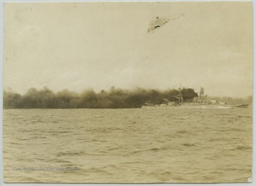 Thick, black smoke billows from an unidentified battleship. 