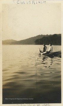 Two people, identified as "Toots" and Fred, lounge along the Cheat River, likely in Preston County.