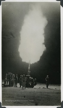 Soldiers gather around a firing anti-aircraft gun during a defense campaign. The photograph comes from a U.S.S. West Virginia scrapbook.