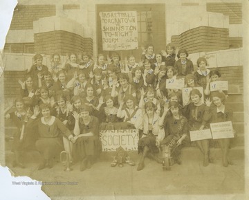 Banner on the door advertises a basketball game between Morgantown and Shinnston. Thirty one out of forty students are identified. See original for identification. 