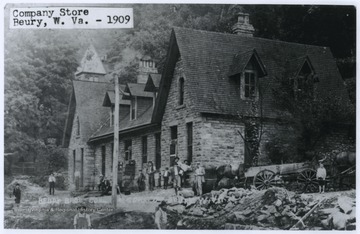 Men are gathered outside of the large brick building in which the Beury Brothers Coal and Coke Company store is located. Subjects unidentified. 