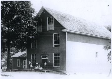 A group of men sit outside of the store's entrance. 