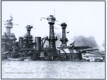 Smoke rises from the sinking battleship, which was hit by seven torpedoes and two bombs. 