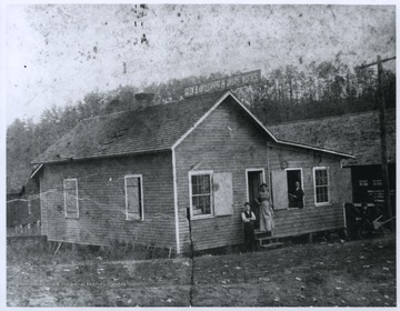 A woman and two men are pictured at the building's entrance. 