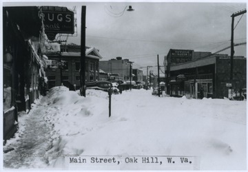 Several feet of snow cover the sidewalks and street.