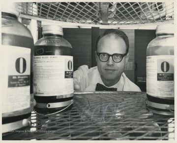 An unidentified man reaches for a bottle of O negative blood. 