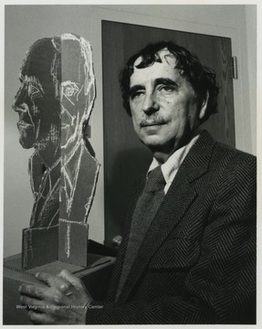 Famed Baltimore sculptor Kramer poses with a mock bust of a WVU faculty member identified as J. B. Rolunseir.