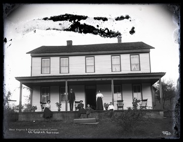 C. C. Graham and family are pictured on the home's porch. C. C. Graham is likely Cyrus C. Graham, born about 1862 in West Virginia.