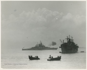 "The guns of U.S.S. West Virginia (BB-48) in operation.  L.C.M.'s in foreground."  L.C.M. stands for Landing Craft Mechanized.