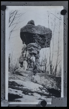 The rock is located near Dayton Vineyard. A group of people pose behind and on top of the rock. 