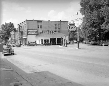 Men work in the service center garage of the Esso station, which is located next to Coffman's Hardware Store. 