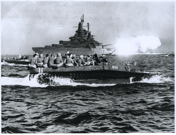 Troops loaded into landing vehicles head for the beaches of Okinawa as part of the largest amphibious assault in the Pacific theater during World War II. The U.S.S. West Virginia is pictured in the background. 