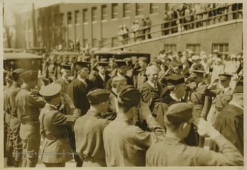 ROTC students form a line as they salute the professors walking down the field. 