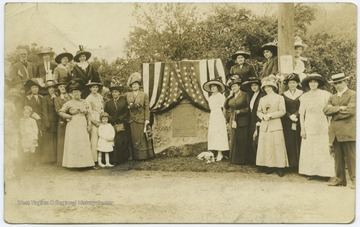 The marker, which is decorated with an American flag, reads, "About one half mile above this point is the 'Great Crossings' of the Youghiogheny River, where George Washington crossed November 18th, 1753, when sent as envoy by Gov. Dinwiddie of Virginia to the French Commandant at Fort Le Boeuf.Washington, on his military expedition to the Ohio, encamped there with his forces, May 18th to 24th, 1754, and from that point explored the Youghiogheny.There, also, Major General Braddock, with his army, crossed June 24th, 1755, on his march against Fort Duquesne."