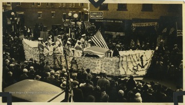 A large float decorated like a boat passes spectators on High Street in Morgantown.