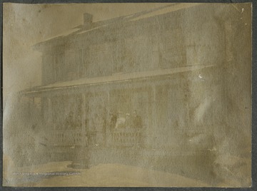 Members of the Glessner family stand on the home porch.This photograph is found in a scrapbook documenting the survey for the B. & O. Railroad in West Virginia and surrounding states. 