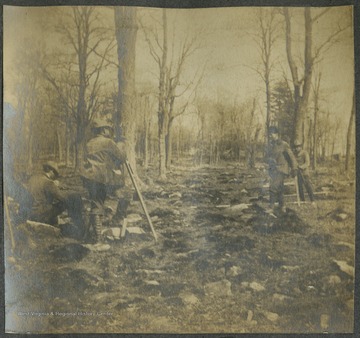 A group of men survey the land for the B. & O. Railroad. Subjects unidentified.This photograph is found in a scrapbook documenting the survey for the B. & O. Railroad in West Virginia and surrounding states. 