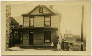 Brooks Nuzum and his sister, Mary E., stand in front of their house on Ohio Avenue in Fairmont, W. Va.