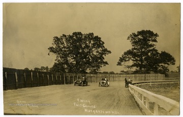 Two cars race a horse-drawn buggy at the Evansdale Race Track.