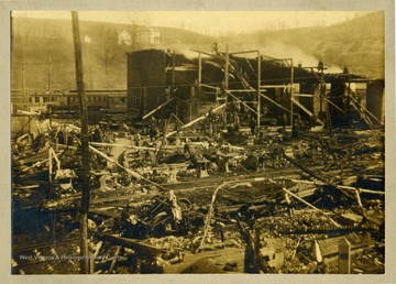 People climb on the wreckage of the Morgantown and Kingwood Railroad repair shops in Sabraton after a fire. 