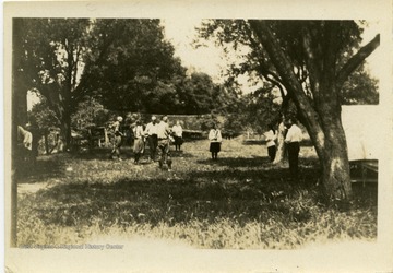 Campers gathered under trees.