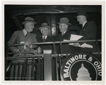 President Franklin Roosevelt pictured with Secretary of State Cordell Hull, Assistant Secretary of Defense Louis A. Johnson, and an unidentified man. 