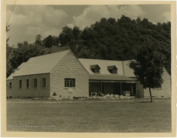 Signs on cottage read: "Electric kitchens; Electric Laundries."