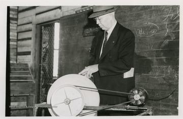 Torner, a Monongahela Power Co. staff member of the Elkins Division sharpens a knife on a motorized grindstone in Millcreek High School Vo-Ag shop.