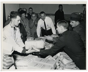 "Members of the Charleston Salvation Army (right) distribute food to the needy, made available under the U.S. Department of Agriculture's increased food distribution plan. Canned pork and gravy, dried beans, dried eggs, and peanut butter have been added to the other abundant foods being distributed in areas where needs are pressing, particularly in areas of high unemployment." USDA office of information photograph.