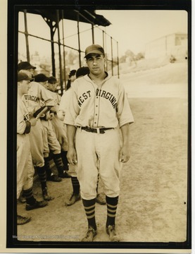 WVU baseball player stands in front of teammates.